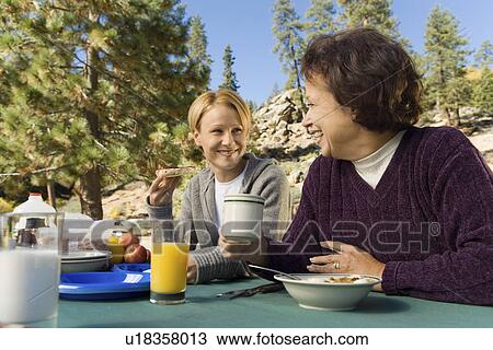 Women eating at picnic table in campground View Large Photo Image Stock Image - Women eating at picnic table in campground. Fotosearch
