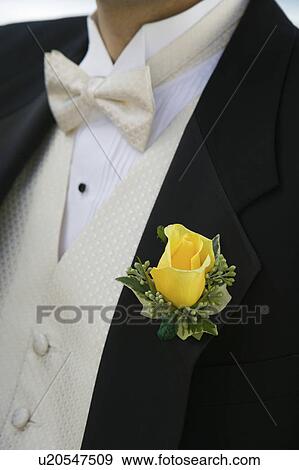 Stock Photo - Yellow rose on Grooms tuxedo, (close-up). Fotosearch