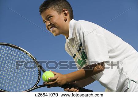 Young boy on tennis court Preparing to Serve, close up, low angle view View Large Photo Image Stock Image - Young boy on tennis court Preparing to Serve, close up, low angle view. Fotosearch
