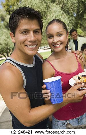 Stock Image - Young couple at outdoor picnic, portrait. Fotosearch