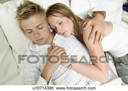 Young couple lying on sofa together, close up, high angle view View Large Photo Image Stock Photography - Young couple lying on sofa together, close up, high angle view. Fotosearch