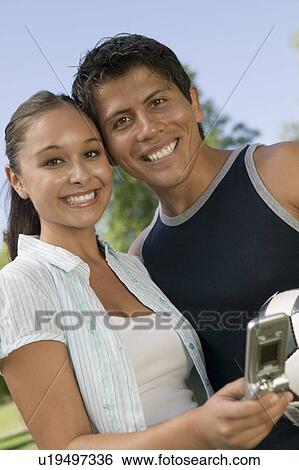 Stock Photograph - Young couple using mobile phone.. Fotosearch