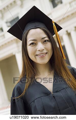 Stock Image - Young female Graduate outside university, portrait. Fotosearch