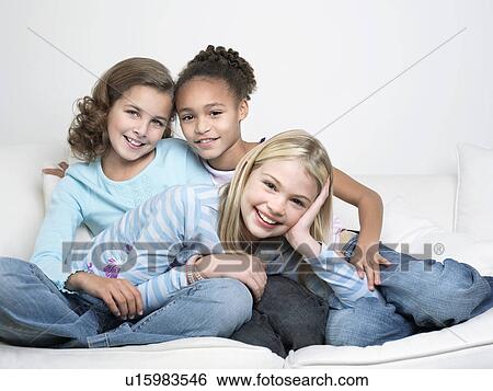 Young Friends sitting, leaning on one another, smiling View Large Photo Image Stock Photograph - Young Friends sitting, leaning on one another, smiling. Fotosearch