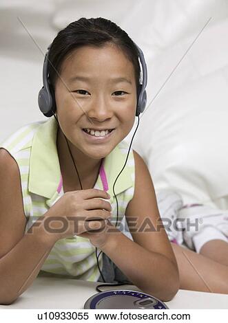 Young Girl on sofa Listening to portable CD player View Large Photo Image Stock Photography - Young Girl on sofa Listening to portable CD player. Fotosearch