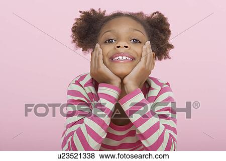 Stock Photo - Young Girl smiling, head in hands. Fotosearch