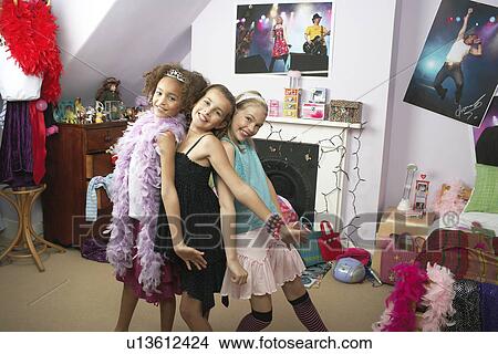 Young Girls striking a pose in trendy bedroom at Slumber Party View Large Photo Image Picture - Young Girls striking a pose in trendy bedroom at Slumber Party. Fotosearch