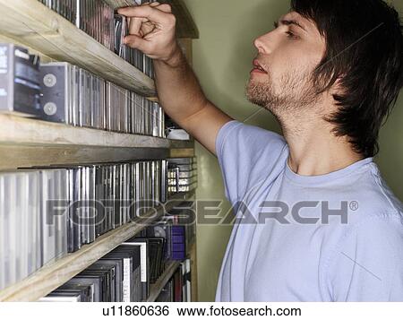 Young man browsing music collection, side view. View Large Photo Image Stock Photograph - Young man browsing music collection, side view.. Fotosearch