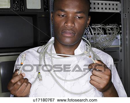 Young man with network cables around neck, front view. View Large Photo Image Stock Photo - Young man with network cables around neck, front view.. Fotosearch
