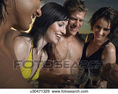 Young people in bathing suits toasting with champagne outdoors View Large Photo Image Stock Photo - Young people in bathing suits toasting with champagne outdoors. Fotosearch