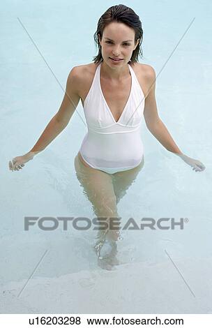 Stock Photo - Young woman in swimming pool, elevated view. Fotosearch