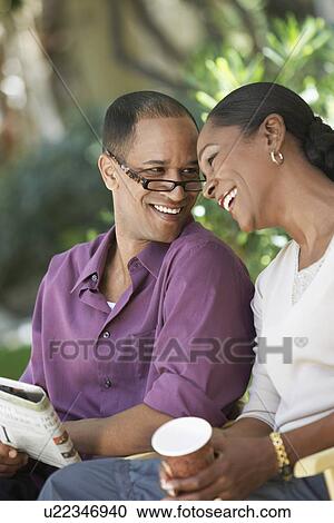 Affectionate mature couple sitting together outdoors View Large Photo Image Stock Image - Affectionate mature couple sitting together outdoors. Fotosearch