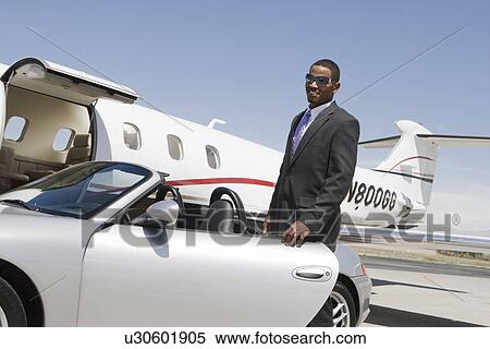 African-American businessman opening door of convertible on landing strip. View Large Photo Image Stock Photography - African-American businessman opening door of convertible on landing strip.. Fotosearch