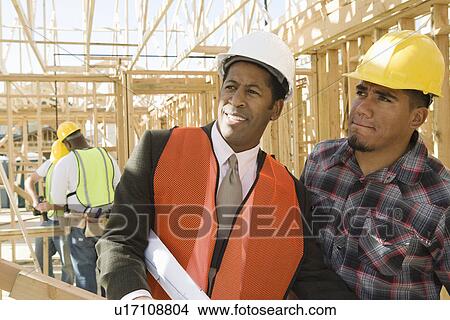 Picture - Architect and construction worker standing on construction site. Fotosearch