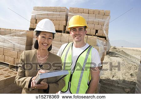 Stock Photo - Architect and construction worker standing on construction site. Fotosearch