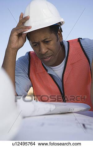 Picture - Architect looking at blueprints. Fotosearch