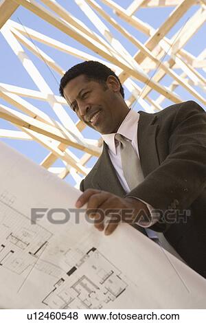 Architect looking at blueprints View Large Photo Image Stock Photo - Architect looking at blueprints. Fotosearch