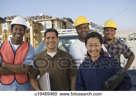Stock Image - Architects and construction workers on construction site. Fotosearch