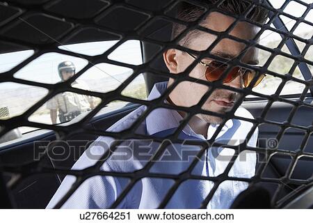 Arrested man sitting in back of police car View Large Photo Image Stock Image - Arrested man sitting in back of police car. Fotosearch
