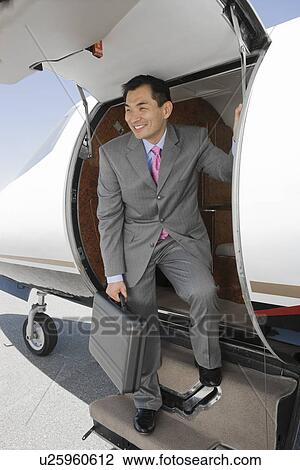Stock Image - Asian businessman getting off airplane.. Fotosearch