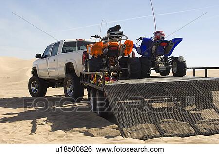 Stock Photograph - ATVs on Trailer Behind Pickup Truck. Fotosearch