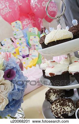 Stock Image - Baby Shower Gifts and Cupcakes arranged on Table. Fotosearch