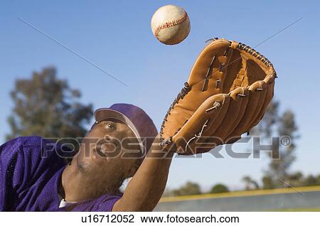 Stock Image - Baseball outfielder catching ball, (close-up). Fotosearch