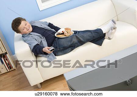 Stock Photo - Boy Eating Donuts. Fotosearch