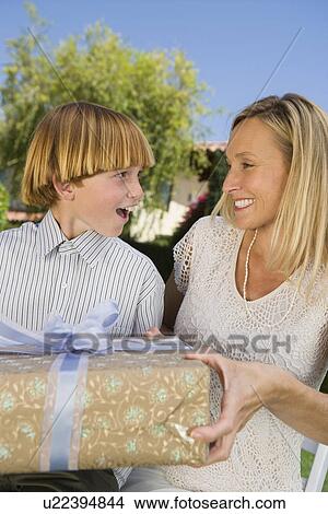 Picture - Boy giving birthday present to his mother. Fotosearch