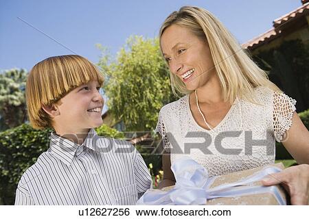 Stock Photograph - Boy giving birthday present to his mother. Fotosearch