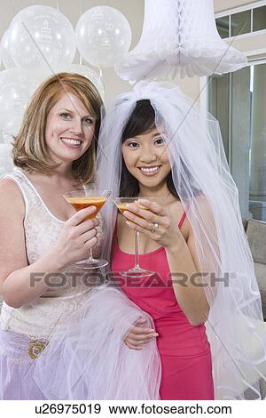 Stock Photo - Bride and friend Drinking Cocktails at Bridal Shower. Fotosearch