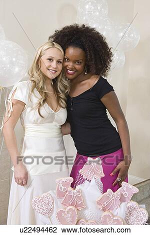 Stock Image - Bride and Friend standing Together at Bridal Shower. Fotosearch