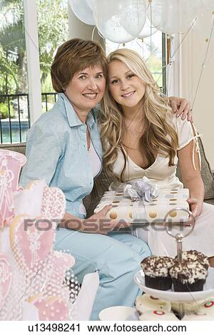 Bride and her Friend sitting Together holding gift at Bridal Shower View Large Photo Image Stock Image - Bride and her Friend sitting Together holding gift at Bridal Shower. Fotosearch