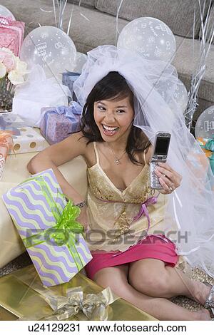 Stock Image - Bride photographing herself using mobile phone. Fotosearch
