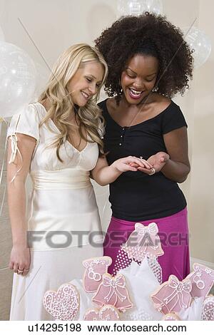 Bride showing friend her engagement ring at Bridal Shower View Large Photo Image Stock Photo - Bride showing friend her engagement ring at Bridal Shower. Fotosearch