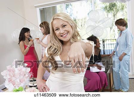 Stock Photo - Bride Showing Off Ring at Bridal Shower. Fotosearch