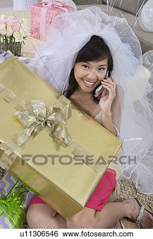 Stock Photograph - Bride using mobile phone at bridal shower. Fotosearch