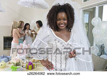 Stock Image - Bride wearing veil at bridal shower. Fotosearch