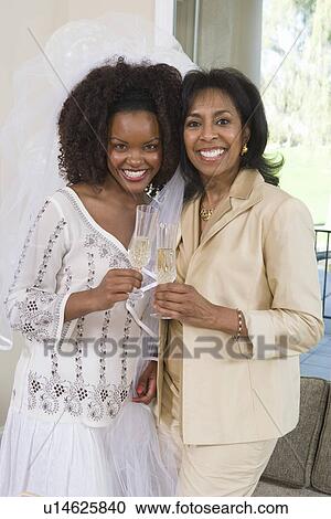 Stock Image - Bride with mother celebrating at bridal shower. Fotosearch