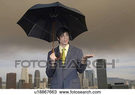 Business man checking for rain under umbrella in city View Large Photo Image Stock Image - Business man checking for rain under umbrella in city. Fotosearch