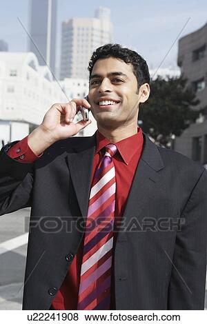 Business man using mobile phone on city street View Large Photo Image Stock Photo - Business man using mobile phone on city street. Fotosearch