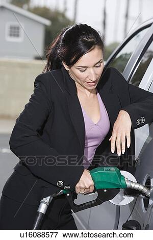 Stock Photo - Business woman with fuel pump. Fotosearch