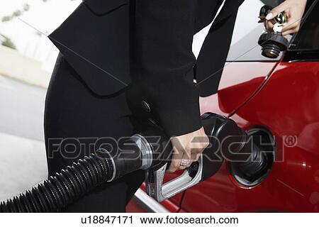 Businesswoman filling car at gas station, mid section View Large Photo Image Stock Image - Businesswoman filling car at gas station, mid section. Fotosearch