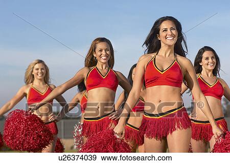 Stock Photo - Cheerleaders doing routine with pom poms. Fotosearch