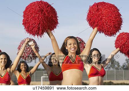 Stock Image - Cheerleaders with pom poms raised. Fotosearch