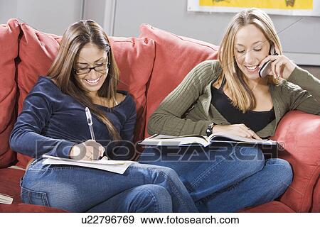 Stock Photo - College students studying together on couch. Fotosearch
