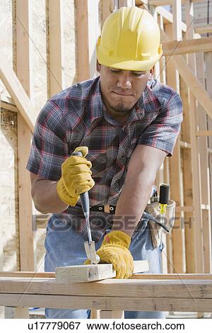 Construction worker at work on building View Large Photo Image Stock Photo - Construction worker at work on building. Fotosearch