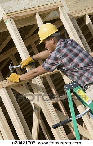 Stock Photograph - Construction worker at work on building. Fotosearch