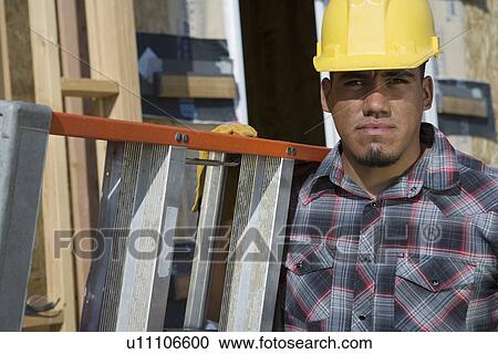 Construction worker carrying step ladder on construction site View Large Photo Image Stock Image - Construction worker carrying step ladder on construction site. Fotosearch