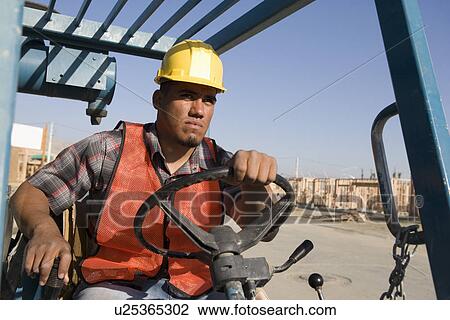 Stock Image - Construction worker driving vehicle. Fotosearch